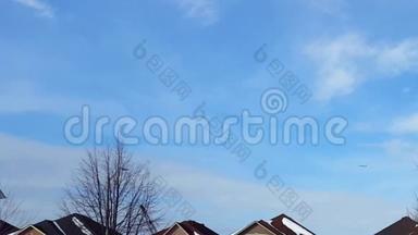 飞机在蓝天中飞过住宅楼的远景。商用飞机飞行、升空和爬升